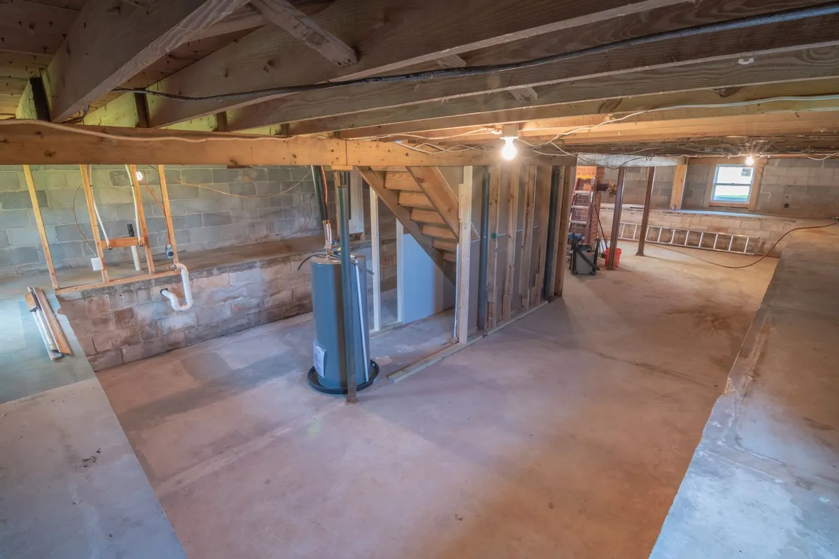 Technician inspecting a basement wood sill with a flashlight