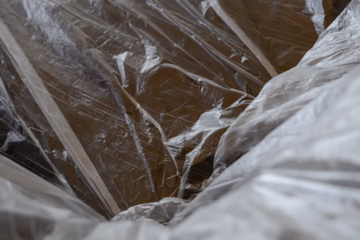 Clean laundry sealed in clear plastic bags on a bed ready for pest treatment