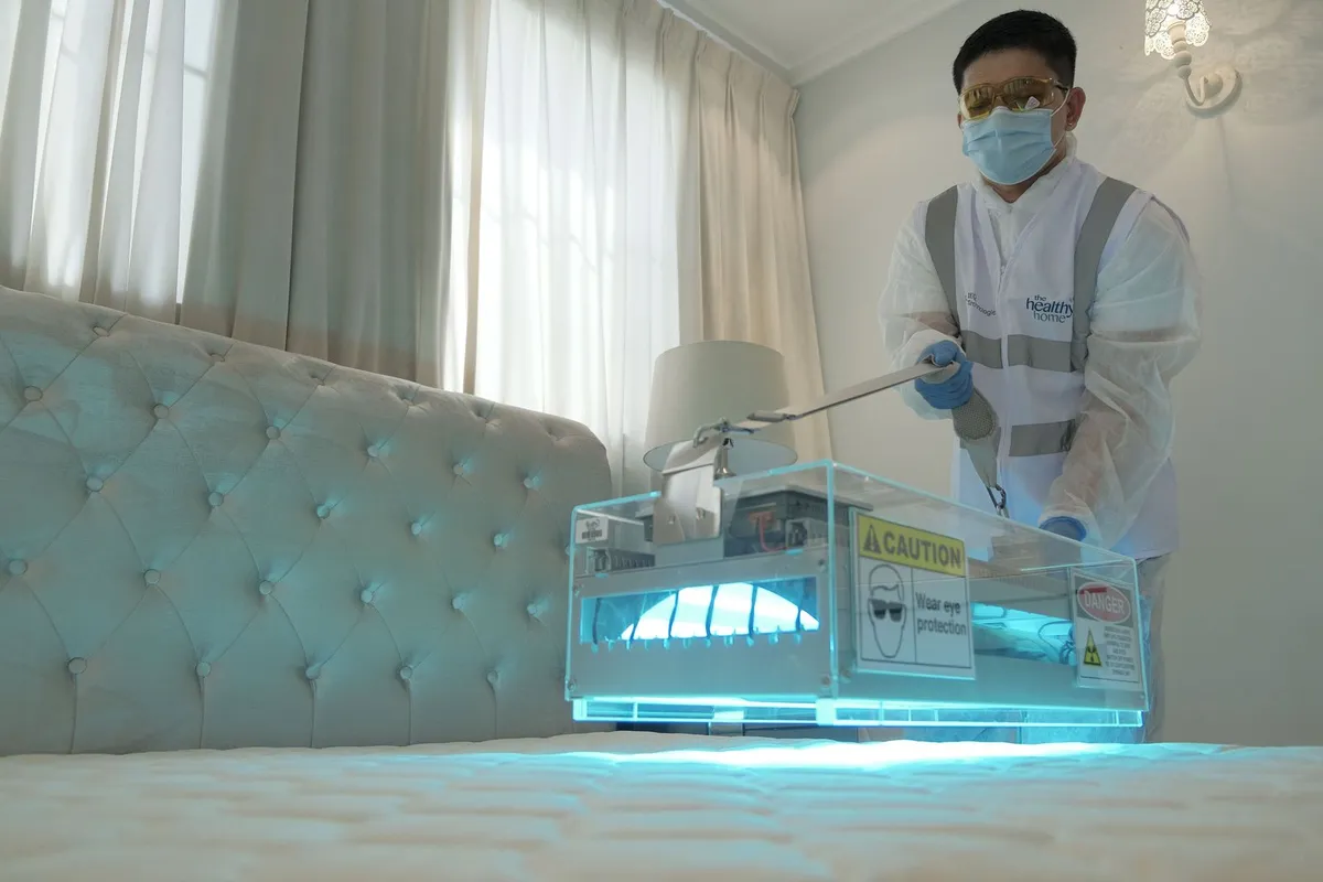 Pest control technician inspecting the seams of a mattress in an apartment