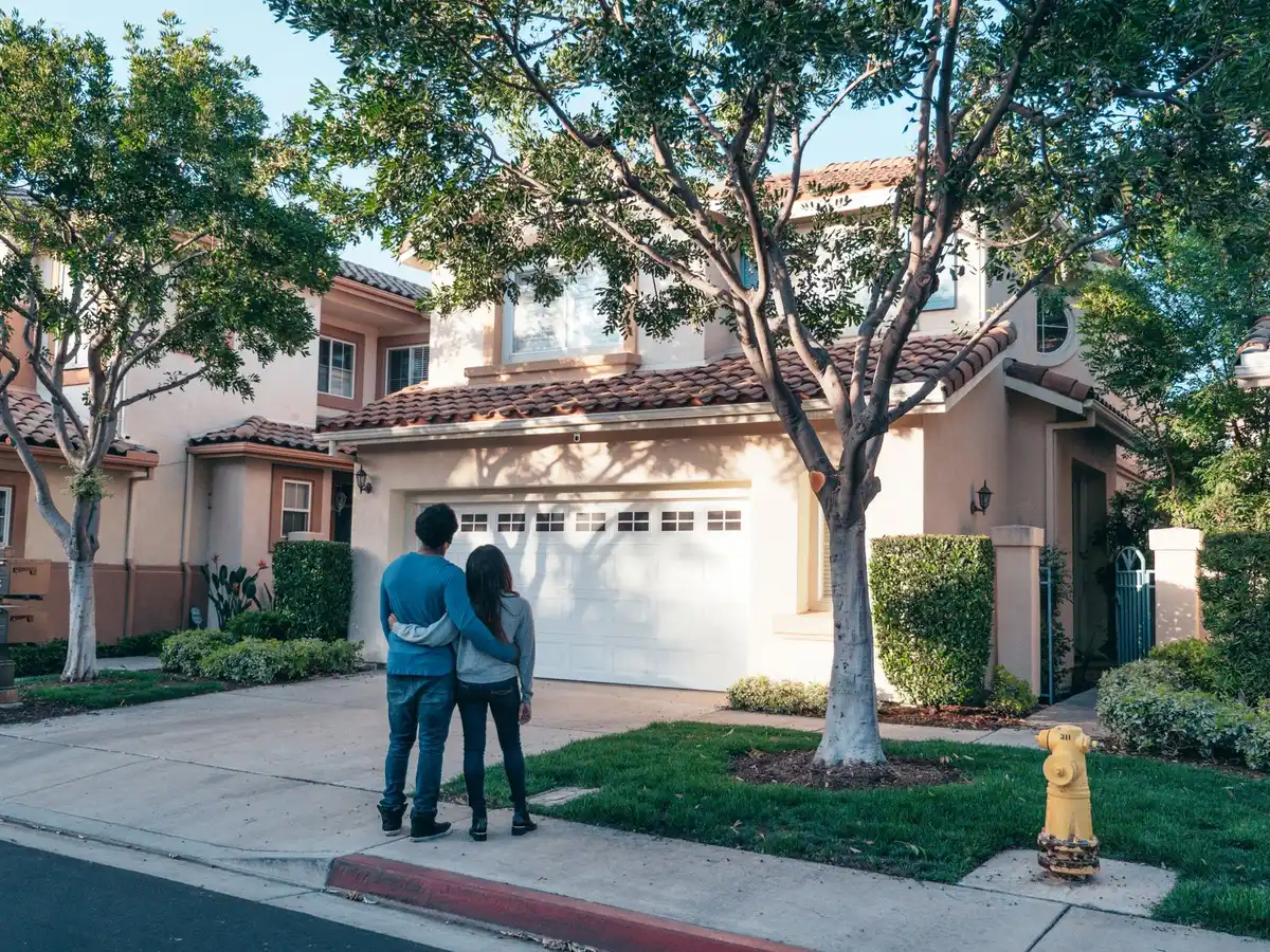 Pest control technician talking with a homeowner in a driveway