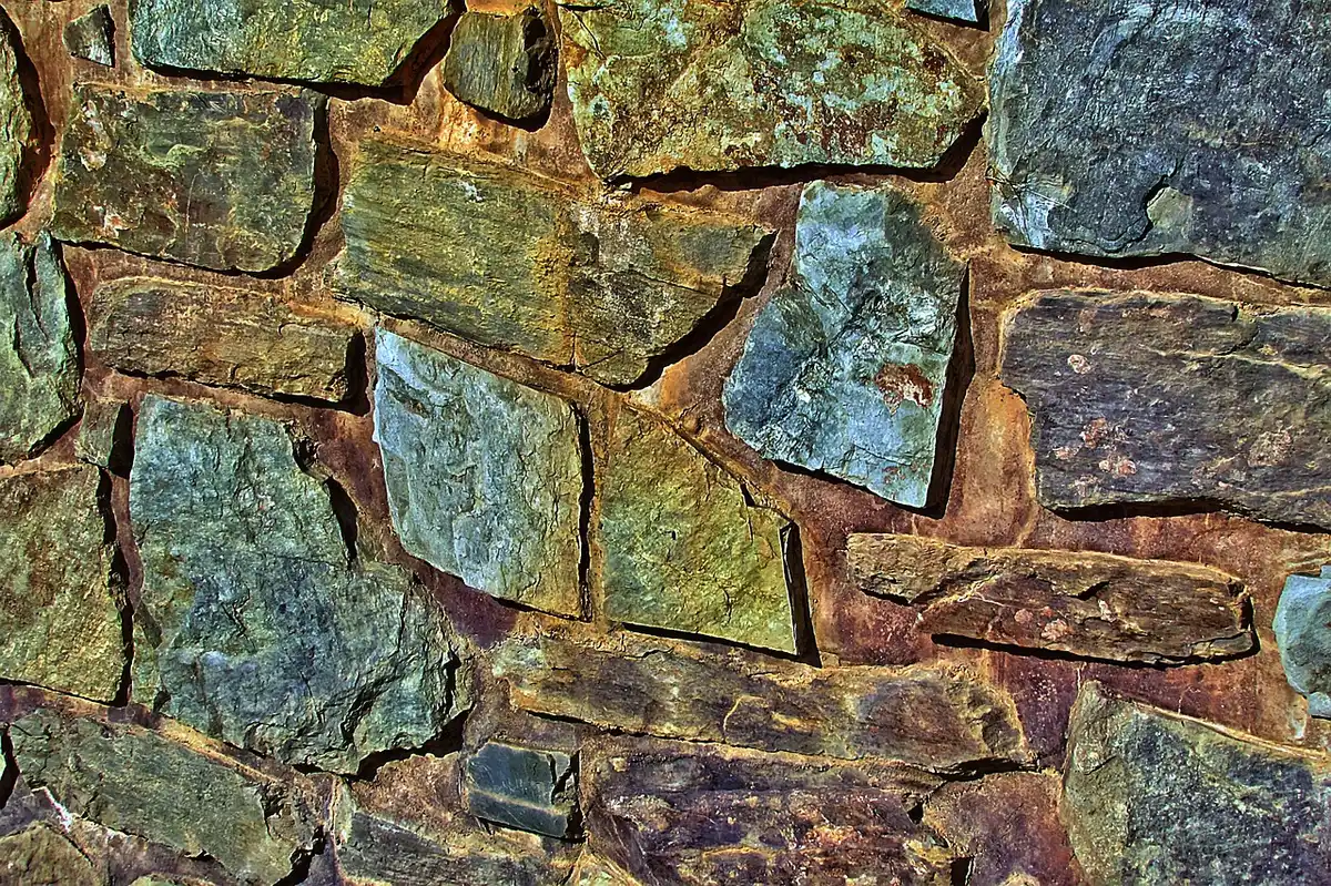 Old stone basement foundation wall with a pipe running through it