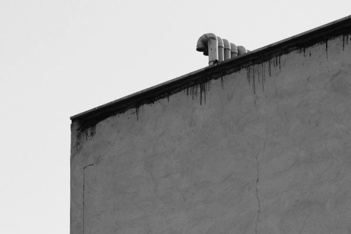 Caulking a gap around a pipe on a house exterior