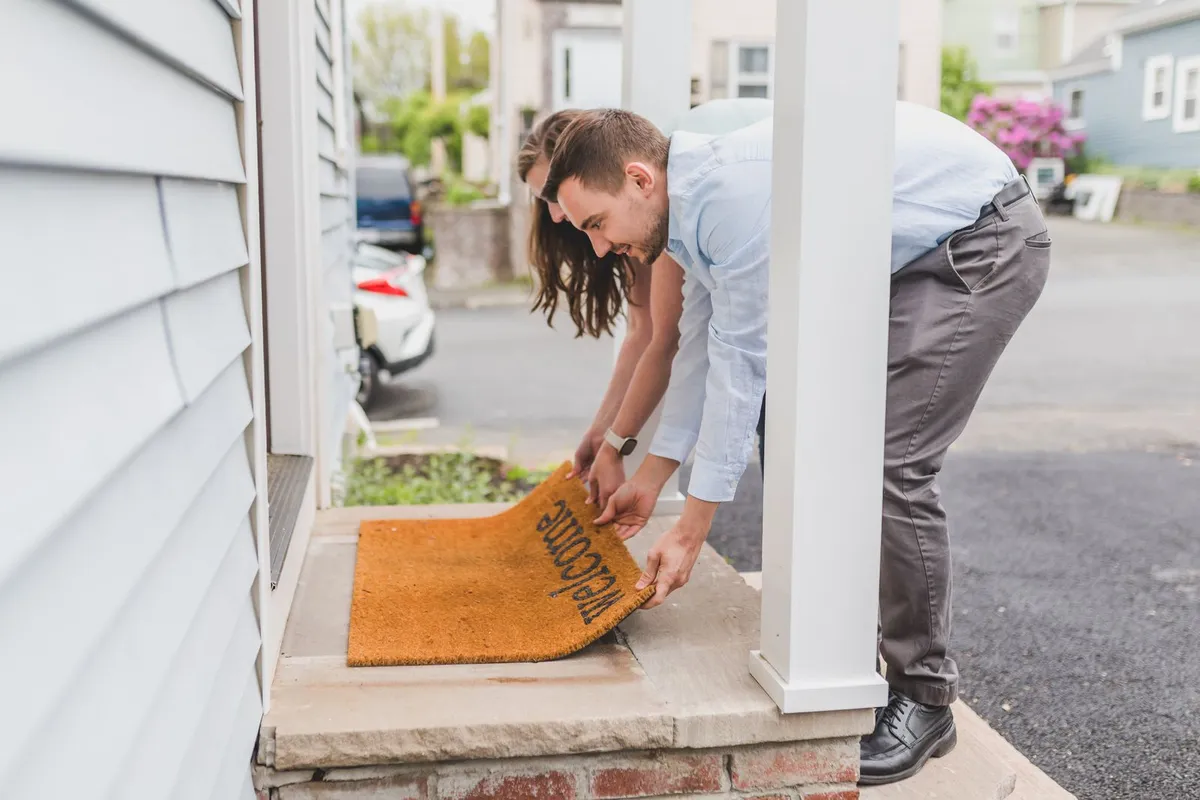 Pest control technician talking with a homeowner on a front porch