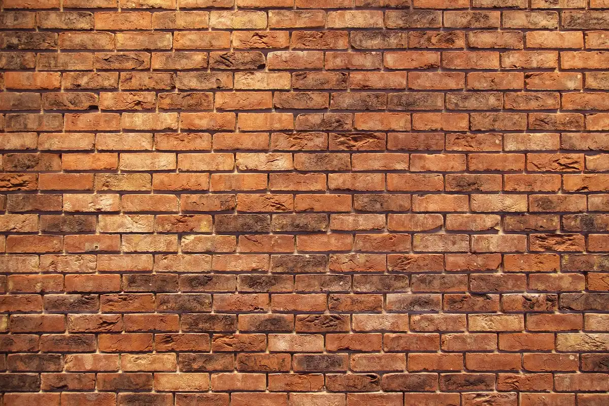 Older brick two-story house with a stone foundation on a Midwest street