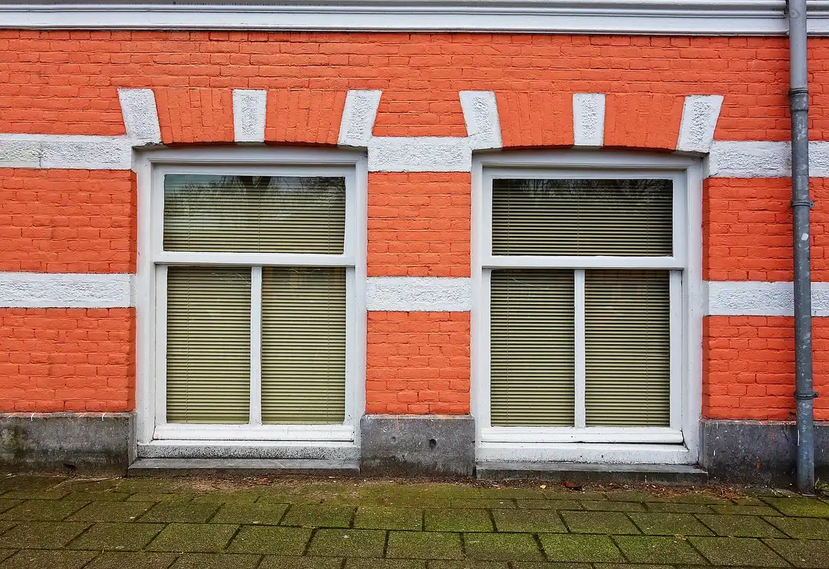 Brick home exterior with a sealed basement window and clean foundation line