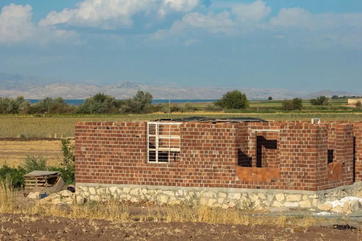 Unfinished basement with stone foundation walls and a small window