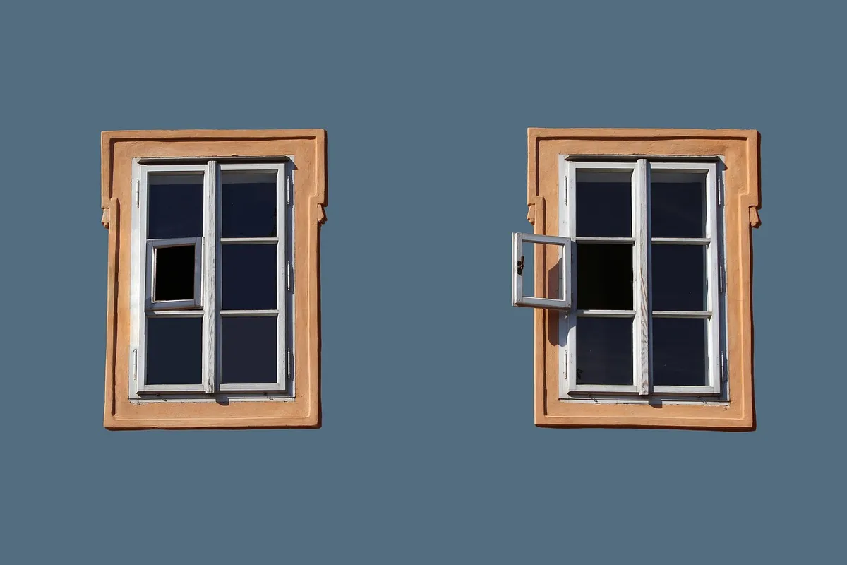 Technician applying sealant along a window frame on a house