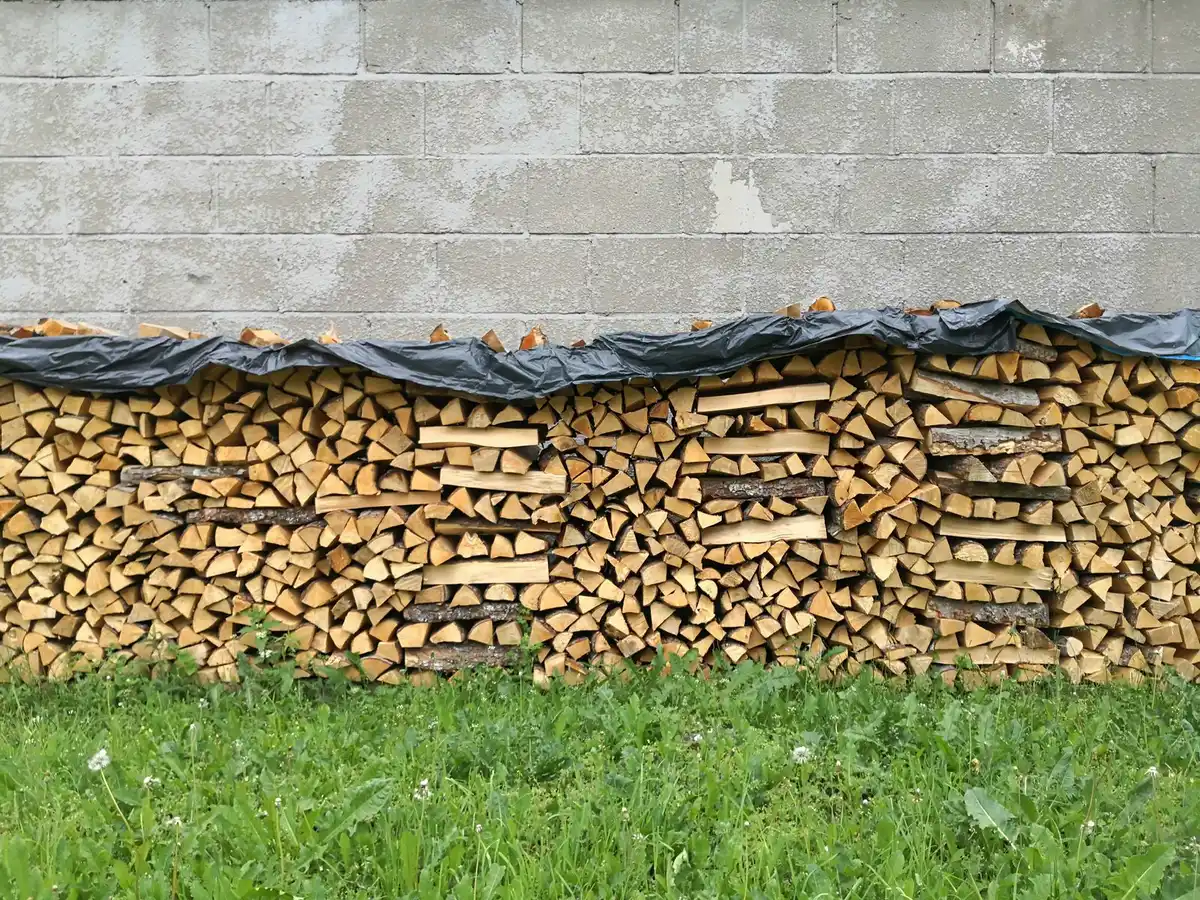Neatly stacked firewood on a rack away from a house wall