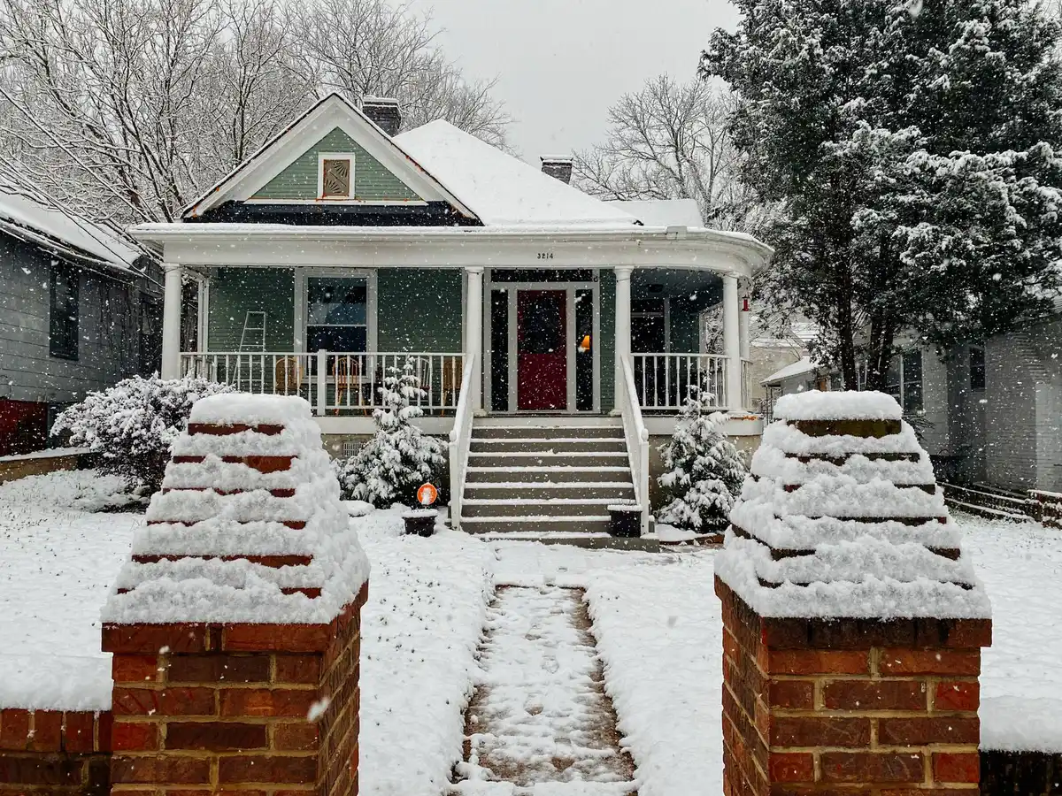 Brick bungalow with a covered front porch on a quiet residential street